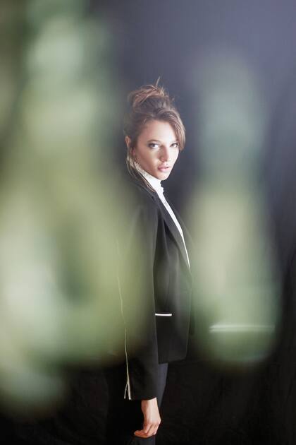 Blazer negro con detalles en blanco de algodón (Vitamina), blusa de algodón con cuello alto color blanco y falda negra de lana (Jazmín Chebar)