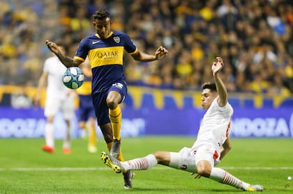 Villa se lleva la pelota ante Huracán, el domingo en la Bombonera. Ese día Boca estrenó el último modelo de camiseta tradicional.