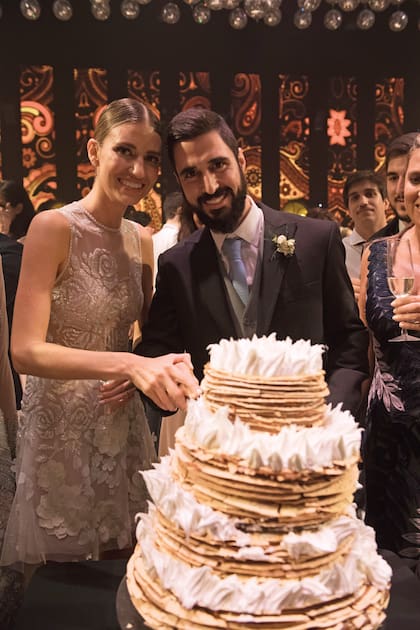 Antes de cortar la torta, Angie se puso un segundo vestido de Lage, con escote ilusión y falda asimétrica. De tres pisos, la torta nupcial –creación de Eat– fue un rogel con merengue
