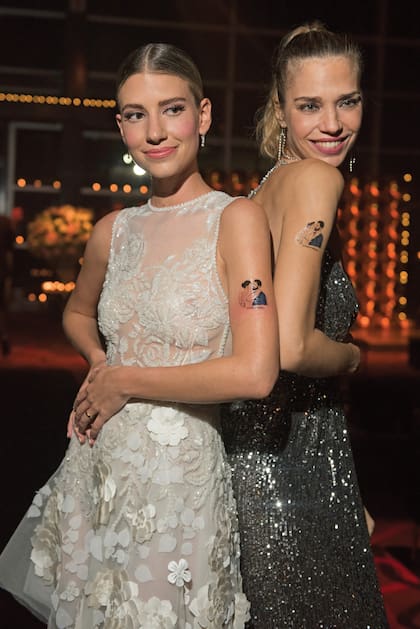 Angie y Lorena Ceriscioli, dueña de la agencia de modelos que la representa desde sus comienzos, muestran el tatuaje de los novios (#the eurnekians) que circularon a modo de cotillón. “Angie brilla de felicidad. Son el uno para el otro”, le confió a ¡HOLA! la ex mannequin