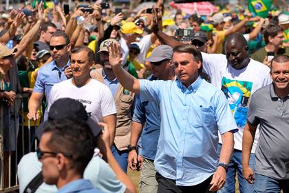 Bolsonaro saluda a simpatizantes a su llegada a una marcha por el Día del Trabajo y la Libertad, el 1 de mayo de 2022, en Brasilia