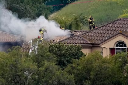 Bombero trabajan en el lugar donde cayó una avioneta en la sección Wood Ranch de Simi Valley, California, el sábado 3 de mayo de 2025. (AP Foto/Mark J. Terrill)