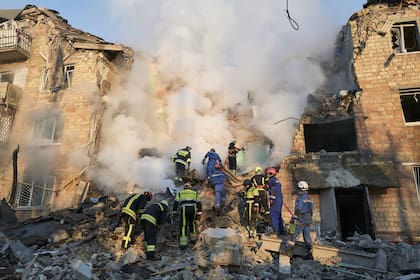 Bomberos apagan las llamas en un edificio residencial tras un ataque con un misil balístico ruso, el 28 de agosto de 2025, en Kiev, Ucrania