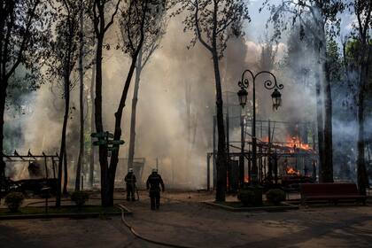 Bomberos apagan un incendio en un parque de Kharkiv. (AP Photo/Felipe Dana)