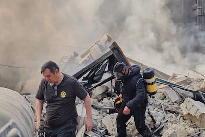 Bomberos caminan entre los escombros de un edificio destruido por un ataque aéreo israelí, el martes 3 de marzo de 2026, en Dahiyeh, un suburbio de Beirut, Líbano
