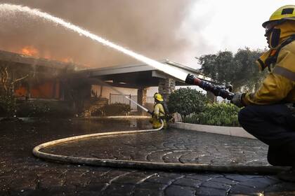 Bomberos de Los Ángeles luchan contra el incendio forestal en la zona de Palisades a 8 de enero. Según el Servicio Meteorológico Nacional, grandes zonas del área de Los Ángeles se encuentran bajo riesgo extremo debido a los fuertes vientos y las condiciones secas.