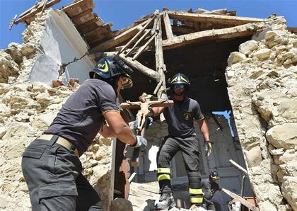 Bomberos italianos recuperan un crucifijo de una Iglesia derrumbada en la localidad de Rio