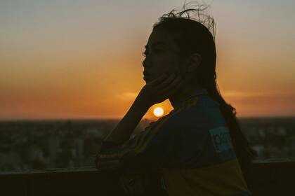 La oscuridad se adueña de la ciudad, pero la camiseta sigue resplandeciendo en esa joven mujer.
