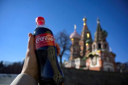 Botella de Coca Cola, al fondo la Catedral de San Basilio en el centro de Moscú, el 9 de marzo de 2022