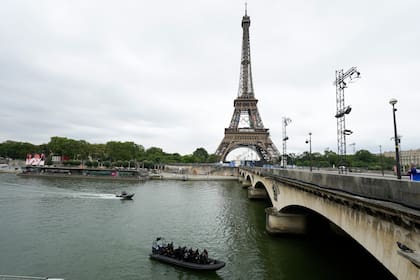 Botes con personal de las fuerzas especiales patrullan el río Sena frente a la Torre Eiffel antes de la ceremonia de apertura de los Juegos Olímpicos 2024 el viernes 26 de julio del 2024. (AP PFoto/Andy Wong)