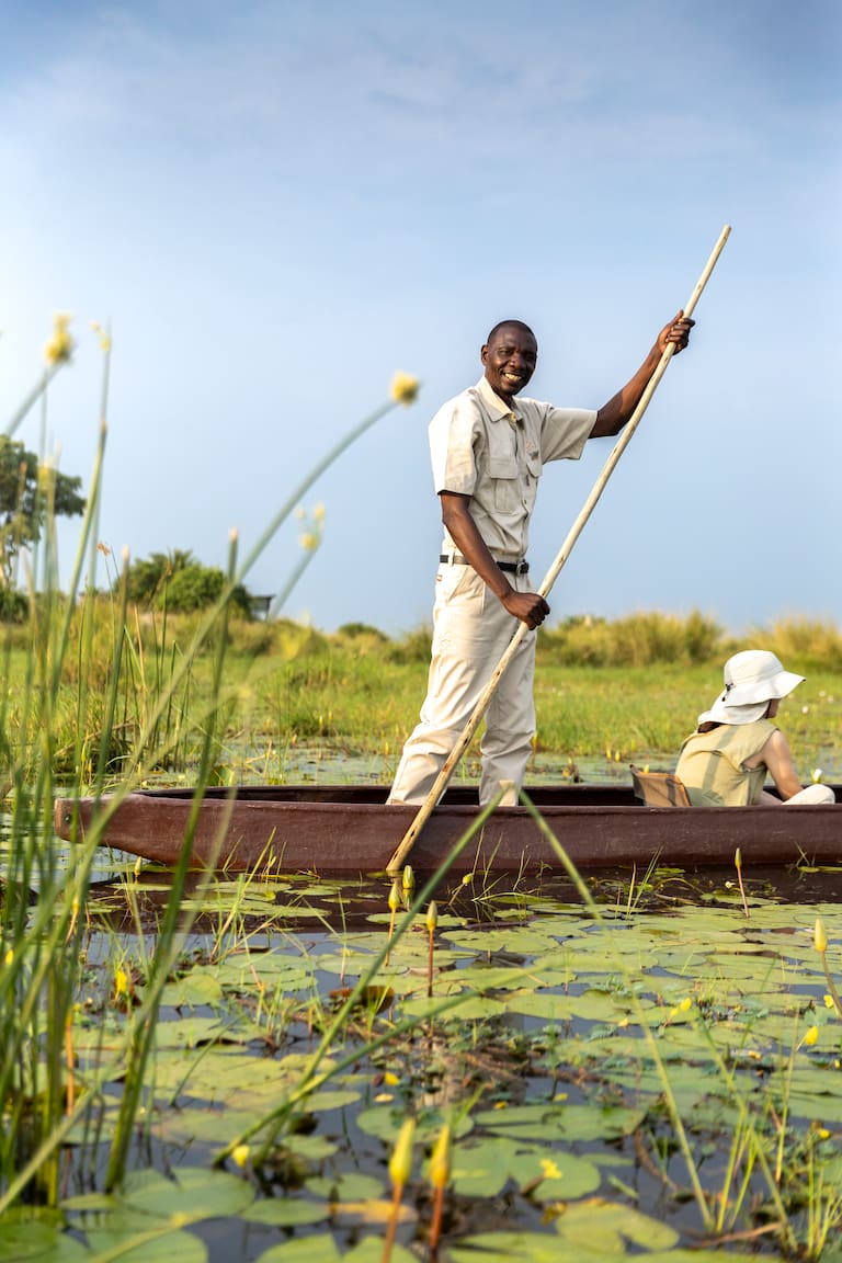Una jirafa entre los arbustos y un “gondolero” avanza en canoa por los riachos del delta. (Fotos: Estrella Herrera)