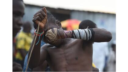 El luchador de Dambe ajusta fuertemente la cuerda a su puño