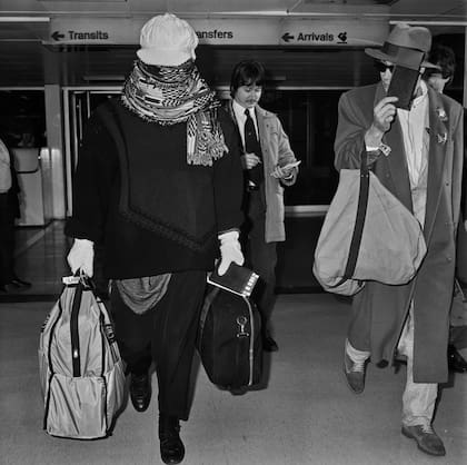 Boy George llega al aeropuerto de Heathrow en 1985 cubriéndose la cara con una bufanda.
