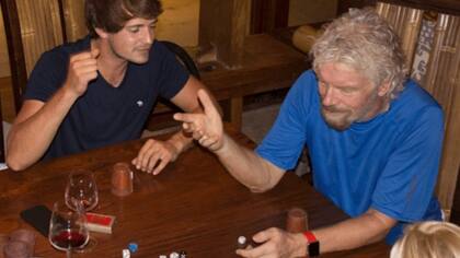 Branson y sus huéspedes jugando a los dados y tomando vino mientas pasa el huracán