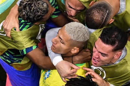 El delantero brasileño Richarlison celebra con sus compañeros de equipo, después de marcar el primer gol de su equipo durante el partido de fútbol del Grupo G, de la Copa Mundial de Qatar 2022