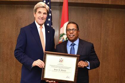 Brian A. Nichols con el exsecretario de Estado norteamericano John Kerry en 2016