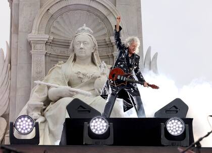 Brian May, desde una tarima, al pie del Monumento a la Reina Victoria, durante el concierto por los 70 años de servicio de la reina Isabel II