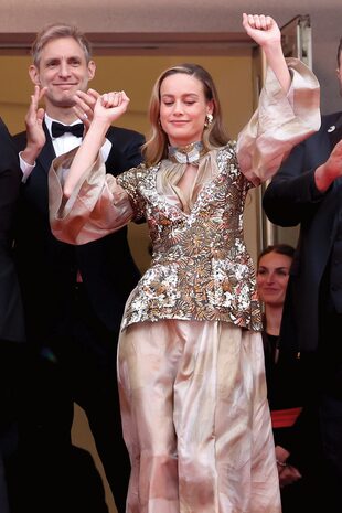 Brie Larson, una diosa de oro con un traje de la colección Chanel Resort 2023, saluda al público junto al director argentino Damián Szifron.