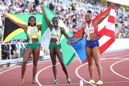 Britany Anderson, de Jamaica, con la medalla de plata, Tobi Amusan de Nigeria y duela del nuevo récord, con la de oro y Jasmine Camacho-Quinn, de Puerto Rico, con la de bronce