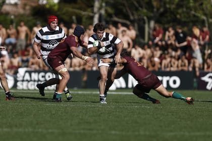 Bruno Devoto avanzando con la pelota para CASI, antes de ser derribado