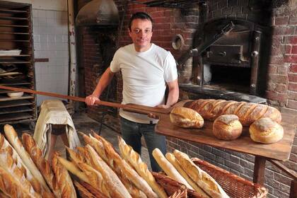 Bruno Guillot preparando pan en el horno de 1911, que es parte de su local L’epi