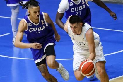 Bryan Canteros persigue a Gabriel Deck; la diferencia de jerarquía fue notable y la Argentina aplastó a Cuba por 56 puntos de ventaja (105-49)