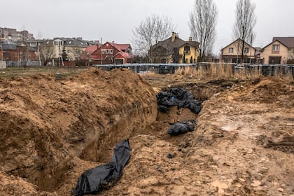 Bodies of civilians who authorities say were killed by Russian forces lay in a mass grave outside St. AndrewÕs Church in Bucha, Ukraine, on Sunday, April 3, 2022. (Daniel Berehulak/The New York Times)