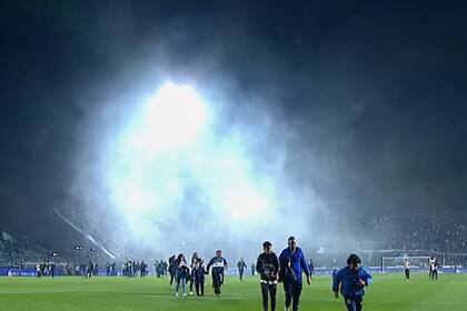 Buena parte del público irrumpió en la cancha para escapar del asedio en las tribunas en medio de los gases lacrimógenos.