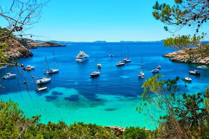 Buques amarrados, veleros, yates y lanchas en Cala Salada, Ibiza
