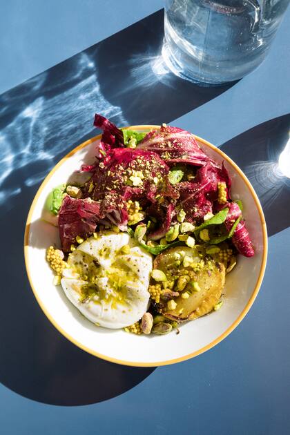 Burrata de estación, peras asadas, radicchio, rúcula, miel y pistachos.