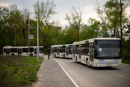 Buses con personas evacuadas desde Mariúpol y otras ciudades llegan a un centro de recepción para personas desplazadas en Zaporiyia, en Ucrania, el 3 de mayo de 2022. (AP Foto/Francisco Seco)