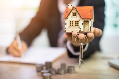 Businessman signs contract behind home architectural model