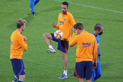 Busquets le da un toque a la pelota, con De Jong y Piqué cerca