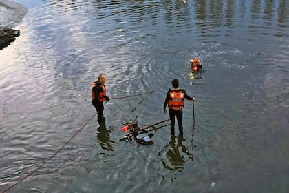 Buzos tácticos retiran del Riachulo la motocicleta del oficial Valiente, quien murió hoy al ser embestido por un vehículo que circulaba en contramano