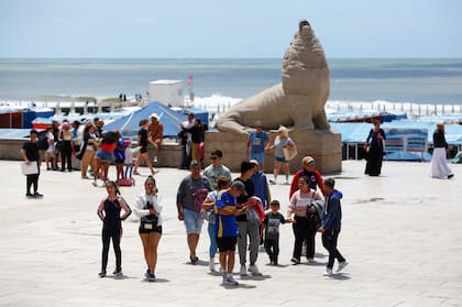 Buzos y pantalones largos en la clásica postal con los lobos marinos de piedra de la Rambla