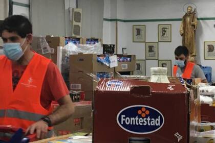 Los voluntarios de la parroquia de San Juan de Dios, en Madrid, organizan los productos para poder aliviar al mayor número de familias posible. 