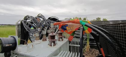 Cables gruesos con cobertores de colores y empalmes fuera de norma sobre el transformador