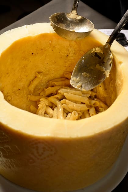 Cacio e pepe, pennette preparados en una horma de queso Pecorino, con pimienta.