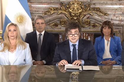 Cada una de las posiciones de los presentes estuvo previamente pensada. En este caso aparece "el jefe" a su lado y en plano sus espadas de Economía y Seguridad, sus dos pilares