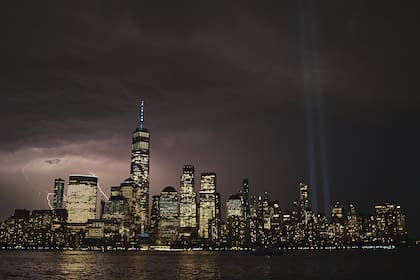 Cae un rayo mientras se ve el Tributo en Luz en el cielo sobre la zona del Bajo Manhattan de Nueva York desde el otro lado del río Hudson en el 22º aniversario de los ataques terroristas del 11 de septiembre, el 11 de septiembre de 2023. (AP/Andres Kudacki)