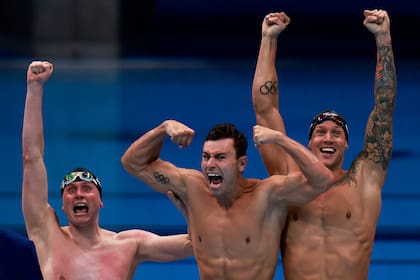 Caeleb Dressel (R) de EE. UU., Blake Pieroni (C) de EE. UU. Y Bowen Becker de EE. UU. Celebran su victoria para llevarse el oro en la final del evento masculino de natación de relevos 4x100m estilo libre durante los Juegos Olímpicos de Tokio 2020 en el Centro Acuático de Tokio en Tokio el 26 de julio , 2021.
