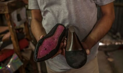 Caleb, el hermano de Heber, sosteniendo los zapatos que Heber estaba haciendo cuando fue detenido.