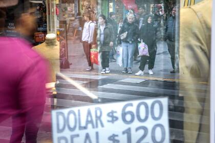 Calle Florida, negocios a la calle con carteles de la cotizacion del dólar blue o paralelo.