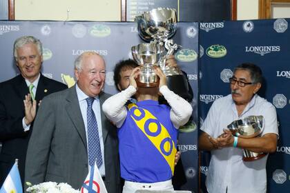 Calvente, detrás de la copa que besa; el Latino quedó en casa