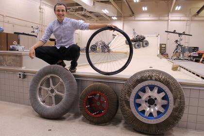 Calvin Young, uno de los ingenieros que participaron del desarrollo de METL, junto a los diferentes modelos de ruedas sin aire creados por la NASA