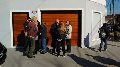 Calvo y con gafas oscuras, Néstor Terrón, junto a allegados, frente a su casa en Avellaneda