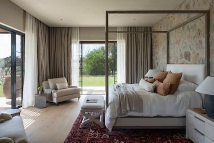 Cama con dosel, un guiño al interiorismo antiguo, aunque con materiales y morfología de indudable actualidad. La alfombra persa fue comprada por los dueños en un viaje; los sillones y el banco, diseñados por Cattarossi.