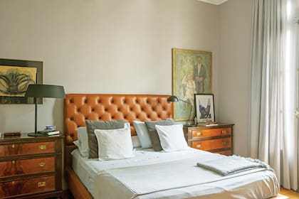 A un lado de la cama con respaldo de cuero capitoné, obra de Julio Hirsch (nombre real del actor Julio Chávez); al otro, obra de Mónica Cancio junto a una copia de Robert Mapplethorpe. Cortinas de pana (De Levie) y manta (Elementos Argentinos). Lámparas (Fábrica de Luz)