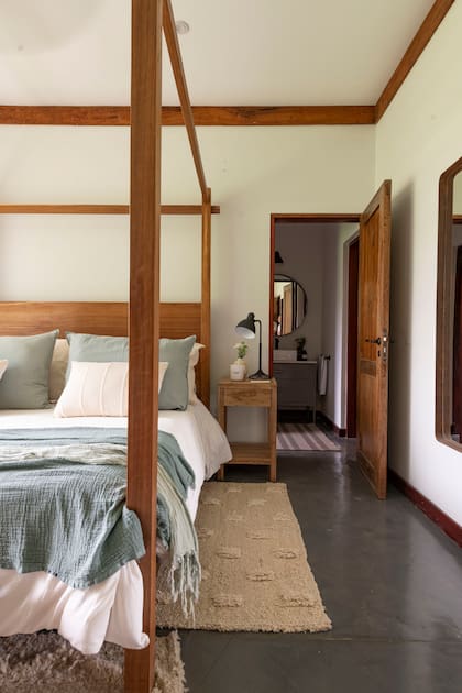 Cama de incienso con dosel y mesas de luz de petiribí, edredón, pies de cama de gasa, alfombra de lana artesanal (todo de L’Epicerie).