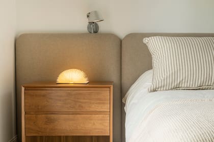 Cama y respaldo hechos a medida (MTD Arquitectura), ropa de cama (Estudio Aarhus). Mesa de noche (Bull Buenos Aires), lámpara de mesa (E27 Iluminación).